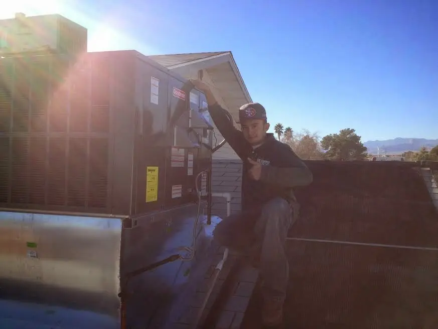 HVAC technician performing Boiler Repair on a rooftop unit in Hastings